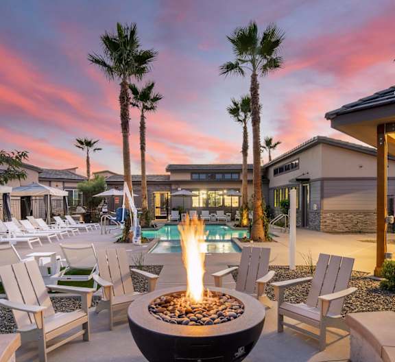 A fire pit sits in the middle of a patio surrounded by chairs. at Grandstone at Sunrise, Peoria, AZ, 85383